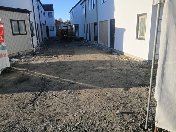 Scraped residential building site between new townhouses in Christchurch — site preparation work.